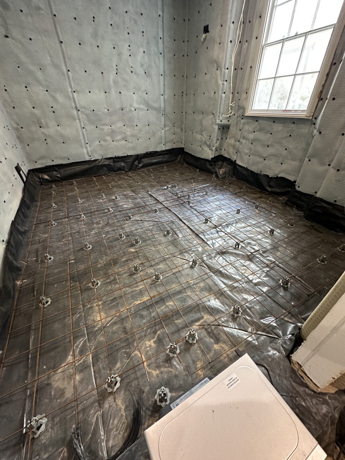 Basement waterproofing in progress — full wall coverage